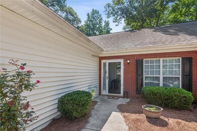 Doorway to property featuring a shingled roof and brick siding