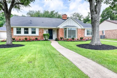 Mature trees and colorful landscaping create an idyllic front space.