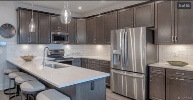 Kitchen with stainless steel appliances, decorative light fixtures, backsplash, dark brown cabinetry, and sink