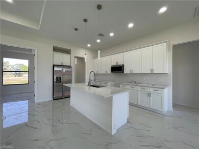 Kitchen featuring appliances with stainless steel finishes, a sink, light marble finish flooring, baseboards, and recessed lighting