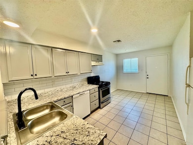 Kitchen with gas range, white dishwasher, under c