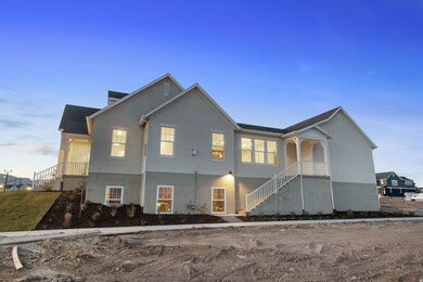 Back of house at dusk with stairway, a shingled roof, and stucco siding