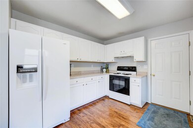 Clean, bright cabinetry with all white appliances.