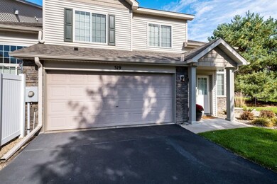 View of 2 car attached garage, & front stoop. Wind