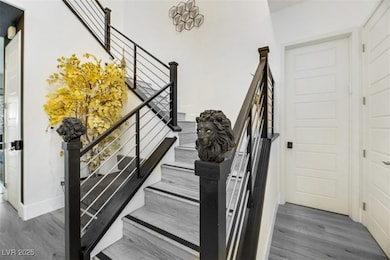 Staircase with wood finished floors and baseboards