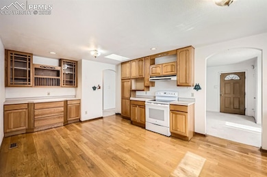Kitchen with arched walkways, light countertops, e