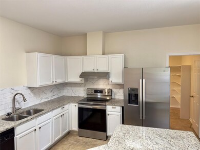 Kitchen with stainless steel appliances, white ca
