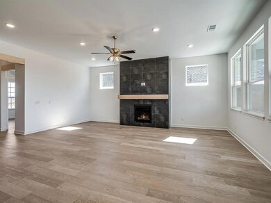 Unfurnished living room with ceiling fan, light wood-style floors, recessed lighting, baseboards, and a fireplace