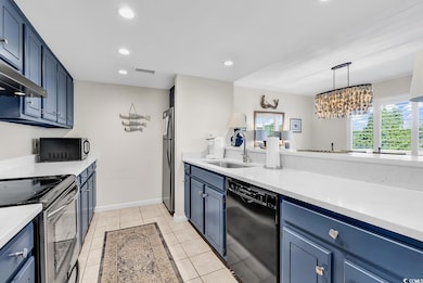 Kitchen featuring light countertops, a sink, black