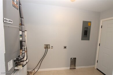 Clothes washing area with light tile patterned flo