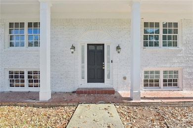 Property entrance with a porch and brick siding