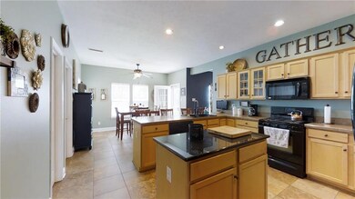 Open Concept to kitchen dining area & overhanging counter for extra dining space.  Slate floors throughout kitchen area.  Walk in Pantry & side door to garage.