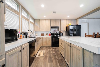 Kitchen featuring black appliances, visible vents,