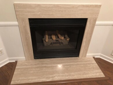 Very lovely fireplace behind china hutch in living room