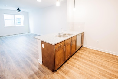 Kitchen with a sink, white dishwasher, light wood