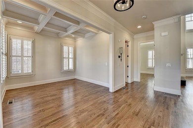 Unfurnished room featuring coffered ceiling, plent