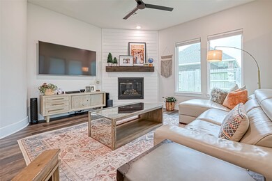 A stellar view of the shiplap style fireplace treatment with wood log mantel. This will be a fun and cozy cuddle spot all year round.