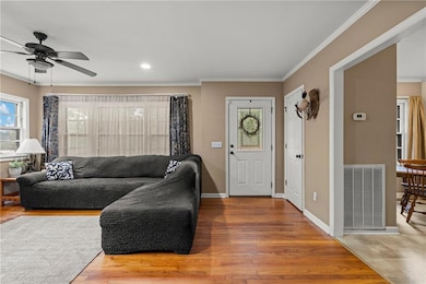 Living area featuring crown molding, Hardwood flooring, and recessed lighting