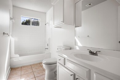 Bathroom featuring shower / bath combination, light tile patterned floors, and vanity