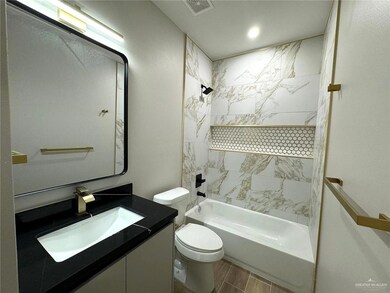 Full bathroom featuring vanity, tiled shower / bath combo, and toilet