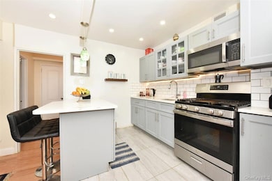 Kitchen with a peninsula, stainless steel appliances, pendant lighting, a breakfast bar, and tasteful backsplash