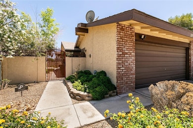 View of side of home with a gate, an attached gara