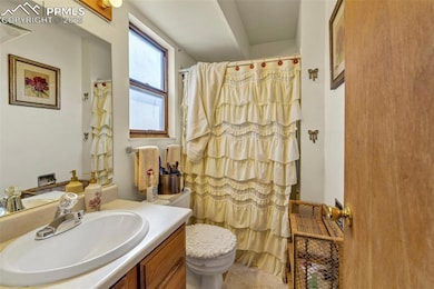 Full bath featuring vanity, a shower with curtain, and toilet