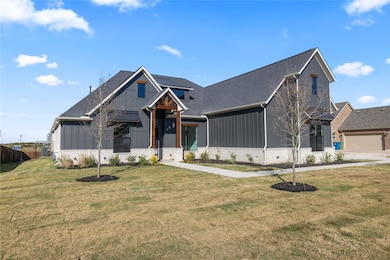Modern inspired farmhouse with board and batten siding, brick siding, and roof with shingles