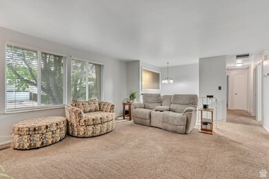 Living room featuring carpet floors and a chandelier