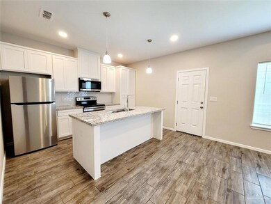 Kitchen with stainless steel appliances, backsplash, white cabinets, light wood-style flooring, and recessed lighting