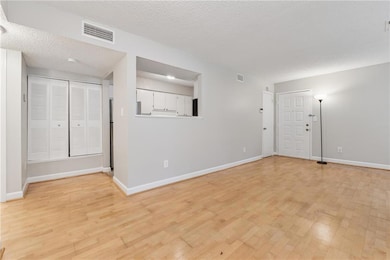 Unfurnished room featuring light wood-type flooring and a textured ceiling