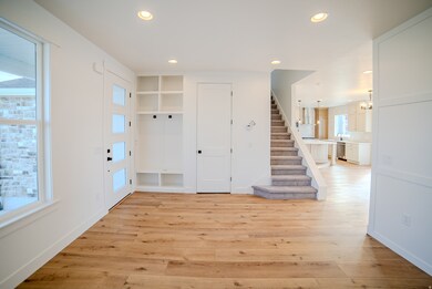 Foyer with recessed lighting, stairway, light wood-type flooring, and a chandelier