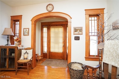 Foyer entrance with plenty of natural light, wood finished floors, and arched walkways