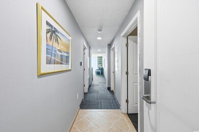 Hallway featuring light tile patterned floors, a textured ceiling, and recessed lighting