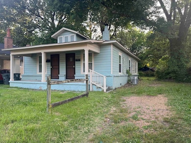 View of front of house with a chimney, a porch, central AC, and a front lawn