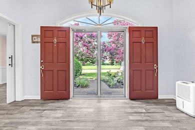 Entryway featuring a chandelier, wood finished floors, and heating unit