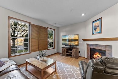 The main-level living room features hardwood floors, large windows with wood plantation shutters, and a cozy gas fireplace.