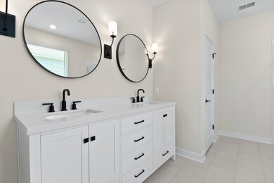 Primary bath features freestanding vanity with dual sinks