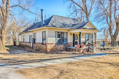 View of front of property with brick siding, covered porch, and roof with shingles