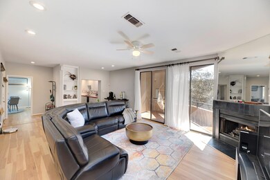 Living area featuring a ceiling fan, light wood-s