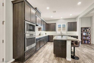 Kitchen with light wood look tile flooring, stainl