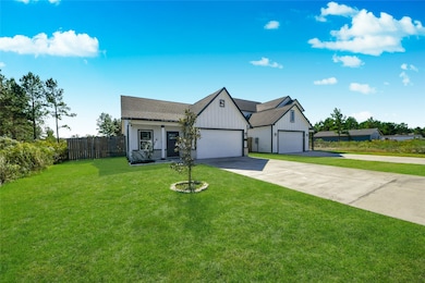 Shows the spacious lot, long driveway, and the overall look of the duplex/townhome style structure with a well-maintained lawn.