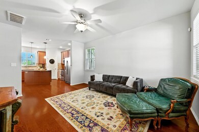 Living area featuring a ceiling fan, dark wood-ty