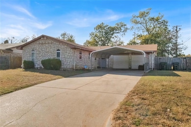 Ranch-style house with stone siding, concrete driveway, and a carport