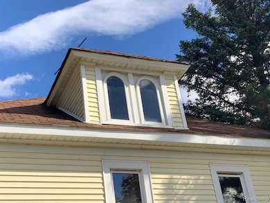 View of side of home with a shingled roof