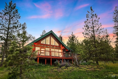 A frame cabin and newer deck looking out onto meadow views.