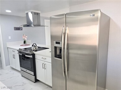 Kitchen with white cabinets, appliances with stain