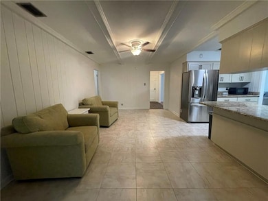 Living area featuring a ceiling fan and ornamental molding