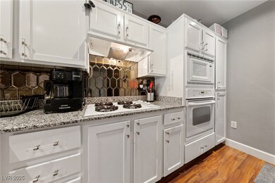 Kitchen featuring tasteful backsplash, light wood-