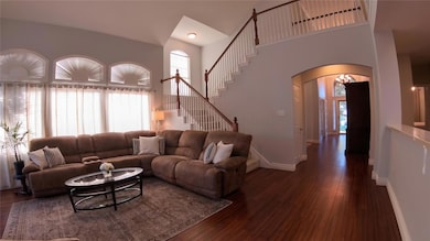 Living room with a high ceiling and dark hardwood 